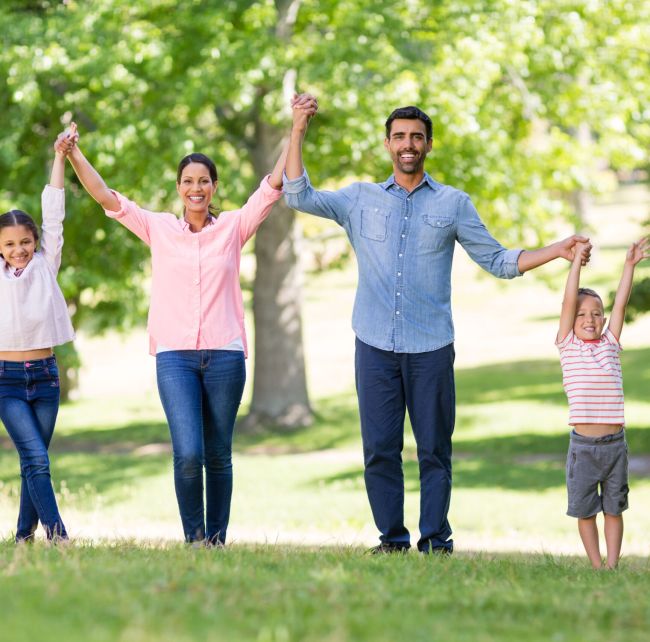 Portrait of happy family enjoying together in park on a sunny day